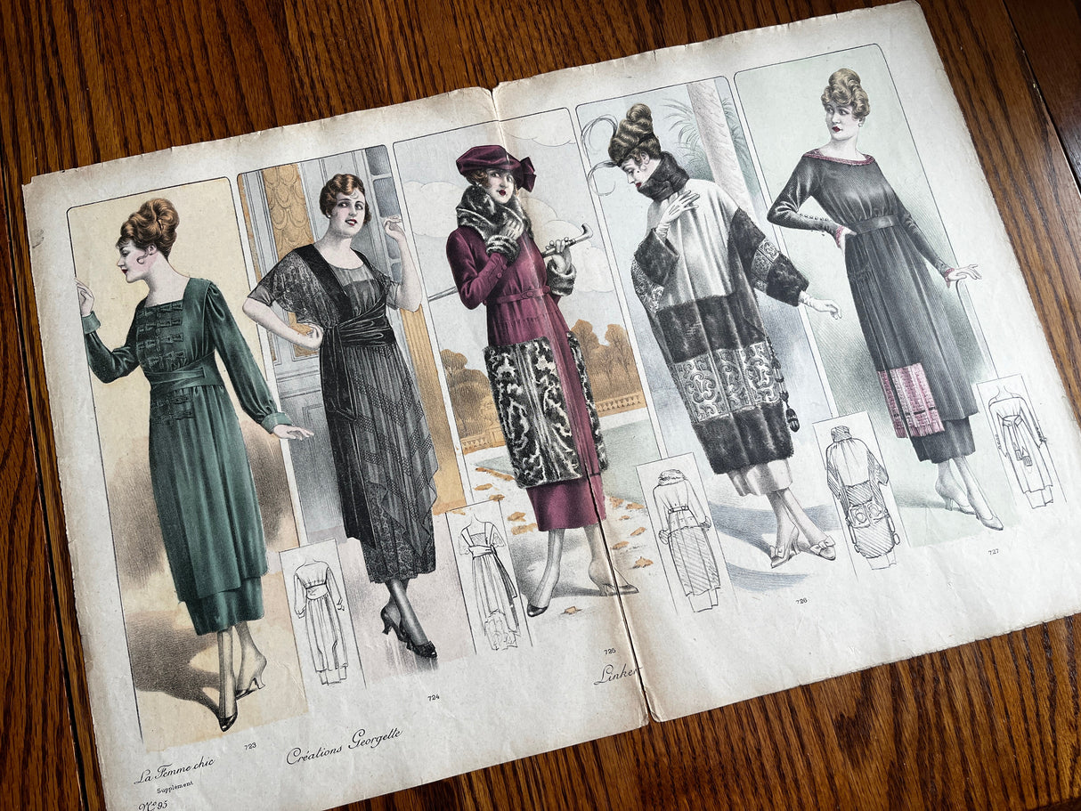 Vintage fashion illustration book open to pages showing women's dresses from the early 20th century.